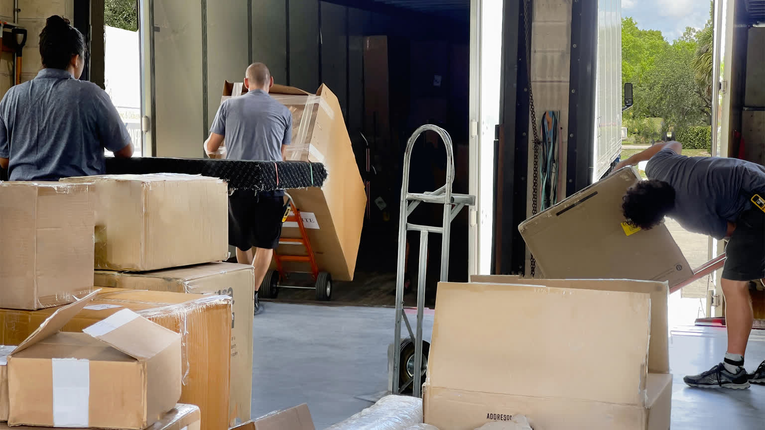 An FDWD crew member unloading wrapped furniture at the Bonita Springs receiving dock.